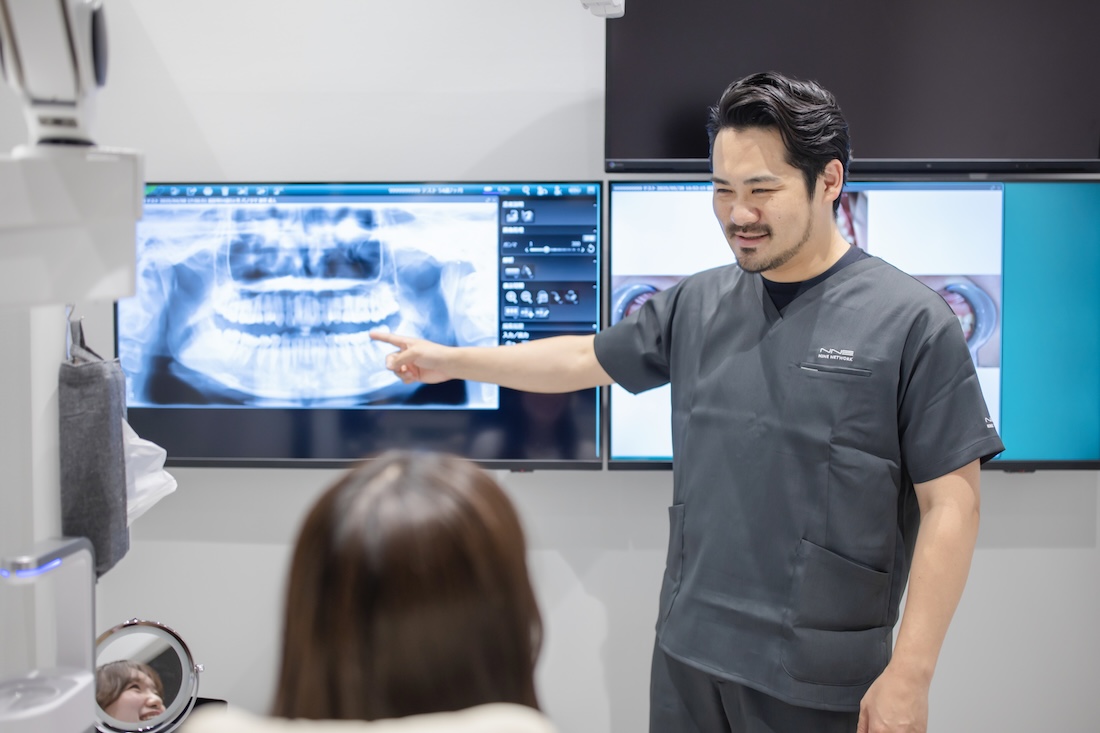 レントゲン画像を使って歯並びの説明をする男性歯科医師